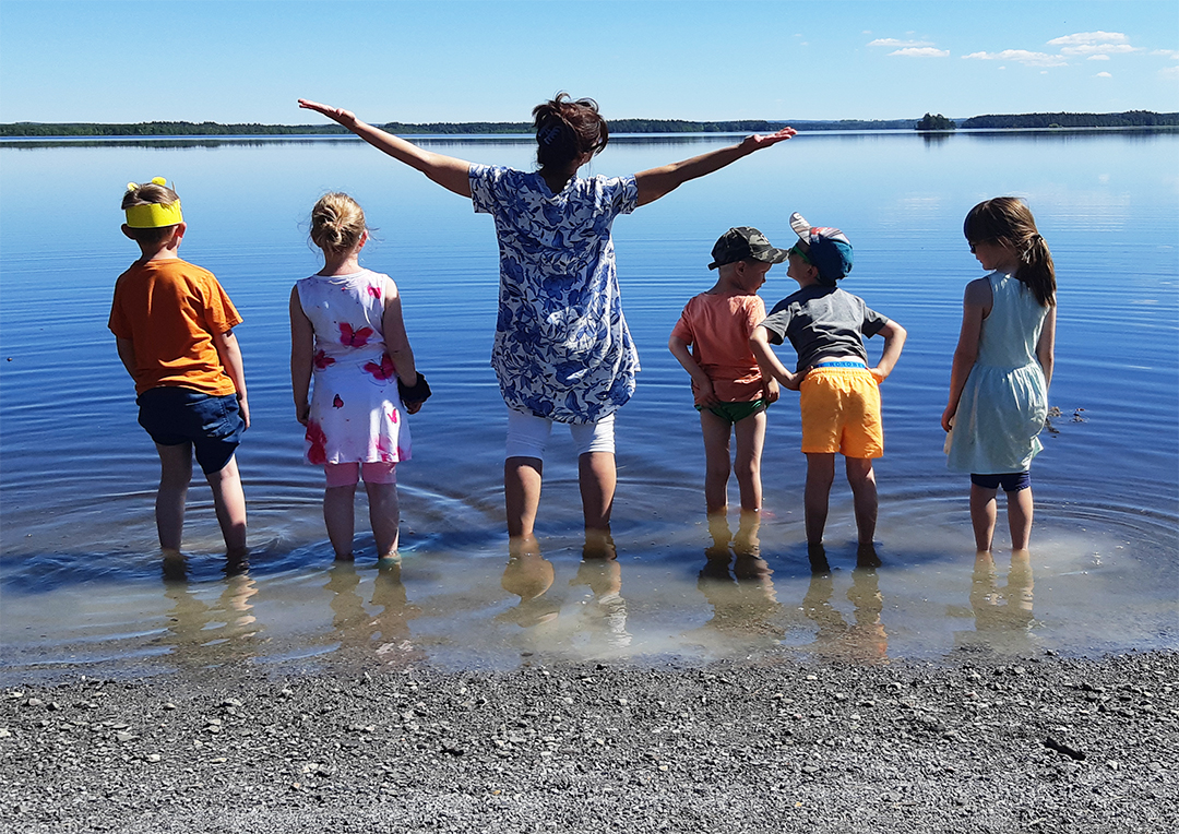 Personal och barn vid stranden