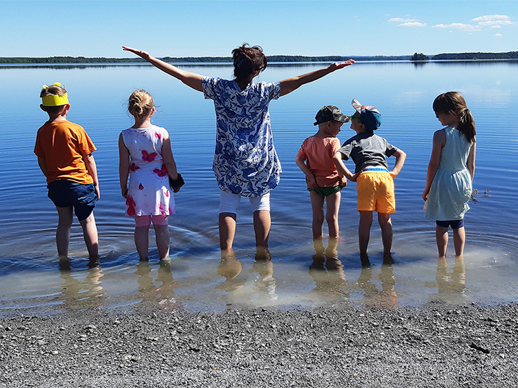 personal och barn vid havet