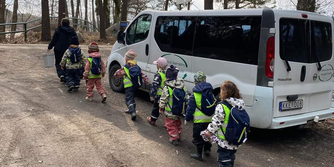 Pedagog och barn på bussutflykt.