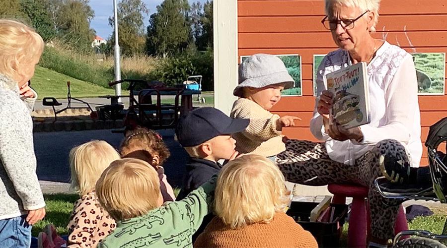 högläsning utomhus pedagog och barn