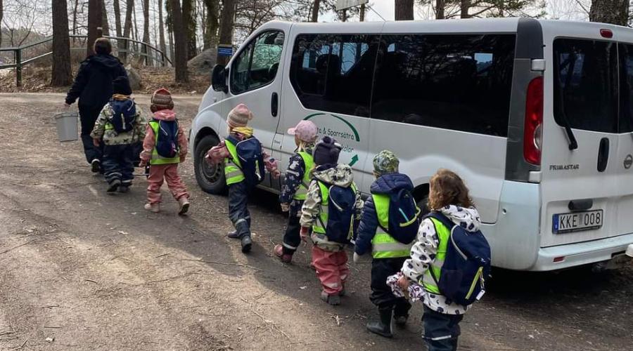 Pedagog och barn på bussutflykt.