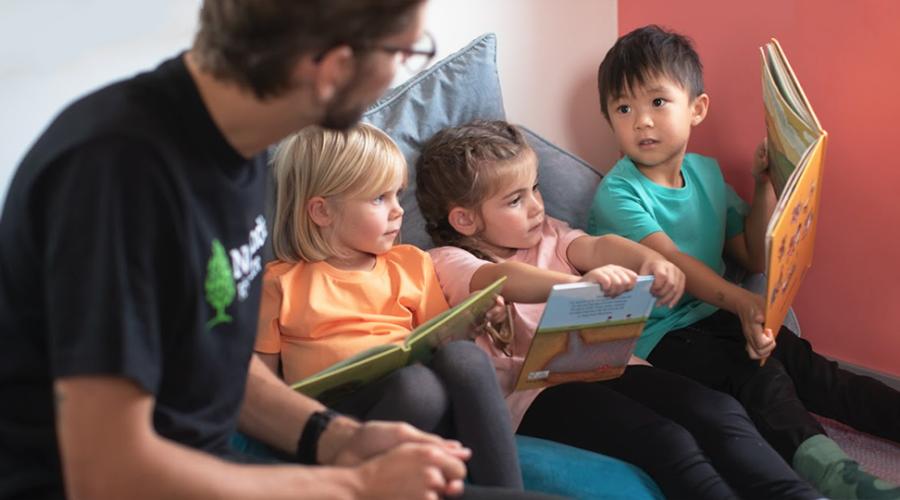 Tre barn under en lässtund på förskolan