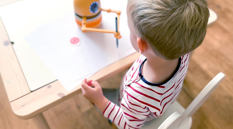 Robot hjälper förskolebarn att rita.